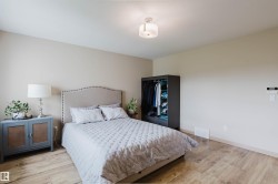 Bedroom featuring warm neutral wall tones and wood-finish flooring - 