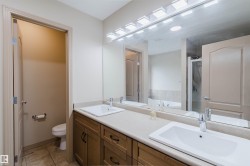 Dual vanity with integrated sinks, a continuous countertop, and wood-finish cabinetry - 