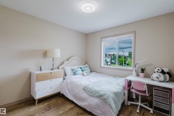 Bright interior room featuring wood-finish flooring, a window with white trim, and a flush-mount ceiling light fixture - 