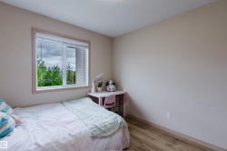Interior room featuring wood-finish flooring, a neutral wall color, and a window with white trim - 