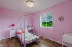 Room featuring wood-finish flooring, a contemporary ceiling light fixture, a window with a white frame and blinds, and baseboard molding - 