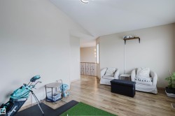 Open common area featuring wood-finish flooring, light-toned walls, and a recessed ceiling light - 