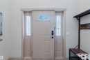 Entryway featuring a panel door with a decorative arched window, sidelight windows with leaded glass, and a black digital lockset - 2236 Garnett Crest, Edmonton, AB 