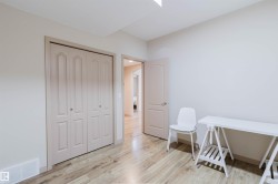 Interior room featuring light-toned walls, wood-finish flooring, and a multi-panel closet with bi-fold doors - 
