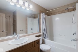 Bathroom featuring a wood-finish vanity with an integrated countertop and single basin sink - 
