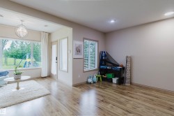 Spacious room featuring wood-finish flooring, ample natural light from multiple windows, and recessed lighting - 