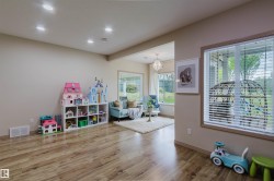 Open-concept living space featuring wood-finish flooring, recessed lighting, and expansive windows - 