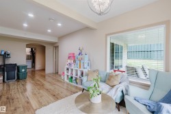 Spacious interior with wood-finish flooring, recessed lighting, and a chandelier fixture - 