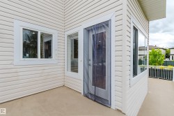 Exterior porch featuring light-colored siding and a neutral-toned floor surface - 