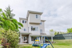 Three-story exterior with light-colored horizontal siding and white trim - 