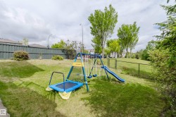 Expansive grassy yard with a dark green privacy fence and a chain link fence - 