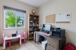 Bright room featuring wood-finish flooring and a large window with roller shades - 