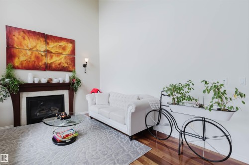 Living area featuring a dark wood-finish mantel and a built-in fireplace with a black grate - 20524 58 Avenue, Edmonton, AB 