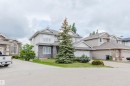 Two-story residence featuring a combination of stucco and stone veneer siding, a gabled roofline, and multiple front-facing windows - 20524 58 Avenue, Edmonton, AB 