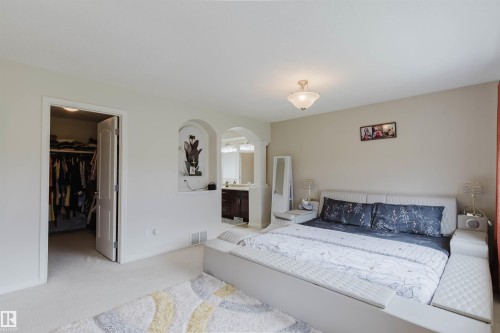 Carpeted bedroom featuring a flush-mount ceiling light and a walk-in closet with an interior light - 20524 58 Avenue, Edmonton, AB 