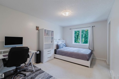 Neutral-toned room featuring a single window, white baseboards, light-colored carpeting, a flush-mount ceiling light fixture, and a white interior door frame - 20524 58 Avenue, Edmonton, AB 