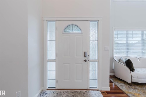White panel entry door with an arched transom window and frosted glass sidelights - 20524 58 Avenue, Edmonton, AB 