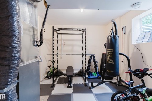 Finished recreation room with light-toned walls and a checkerboard-patterned floor - 20524 58 Avenue, Edmonton, AB 