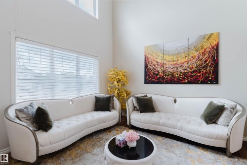 Double-height ceilings complement the expansive windows with horizontal blinds - 20524 58 Avenue, Edmonton, AB 