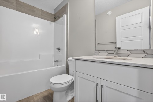 Bathroom featuring a white vanity with a quartz-finish countertop, undermount sink, and chrome faucet - 90 1010 Rabbitt Hill Road Sw, Edmonton, AB - Indoor Photo Showing Bathroom