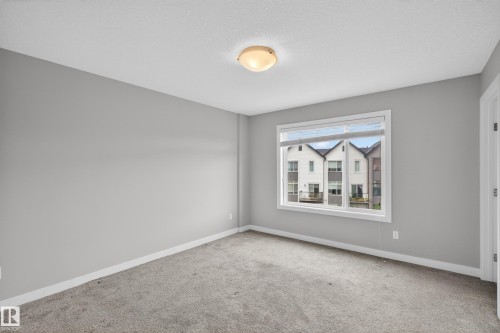 Room with light grey walls and grey carpet flooring - 90 1010 Rabbitt Hill Road Sw, Edmonton, AB - Indoor Photo Showing Other Room