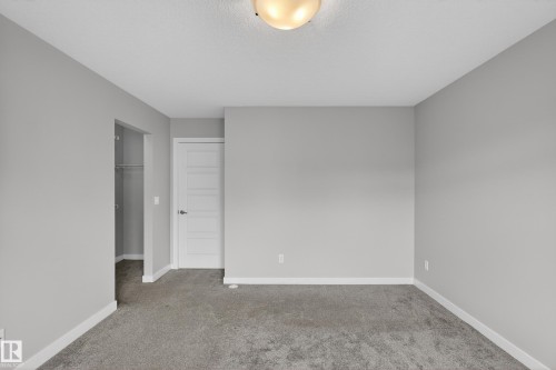 Gray carpeting with white baseboards and light gray walls - 90 1010 Rabbitt Hill Road Sw, Edmonton, AB - Indoor Photo Showing Other Room