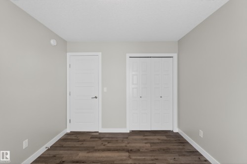 Interior room featuring neutral wall paint, wood-finish flooring, and white trim - 90 1010 Rabbitt Hill Road Sw, Edmonton, AB - Indoor Photo Showing Other Room