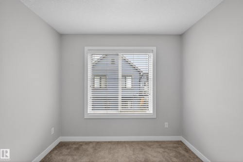 Neutral wall paint with textured ceiling, white trim, and carpet flooring - 90 1010 Rabbitt Hill Road Sw, Edmonton, AB - Indoor Photo Showing Other Room