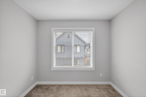 Neutral gray wall paint with white trim, a single window with white blinds, and plush carpet flooring - 90 1010 Rabbitt Hill Road Sw, Edmonton, AB - Indoor Photo Showing Other Room