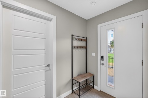 Entryway featuring a contemporary white door with a vertical glass insert and digital lock - 90 1010 Rabbitt Hill Road Sw, Edmonton, AB - Indoor Photo Showing Other Room