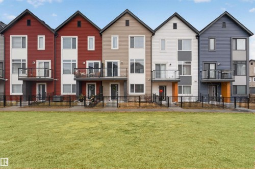 Modern townhome exteriors featuring gabled roofs and individual balconies with glass railings - 90 1010 Rabbitt Hill Road Sw, Edmonton, AB - Outdoor With Balcony With Facade