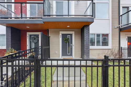 Modern townhome facade featuring a dark gray entry door - 90 1010 Rabbitt Hill Road Sw, Edmonton, AB - Outdoor With Balcony