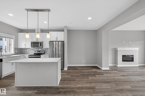 Modern kitchen featuring white cabinetry, stainless steel appliances, and a central island with a solid surface countertop - 90 1010 Rabbitt Hill Road Sw, Edmonton, AB - Indoor Photo Showing Kitchen With Stainless Steel Kitchen With Upgraded Kitchen