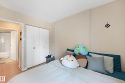 Bedroom with wood-finish flooring, light-colored walls, and a white bi-fold closet - 