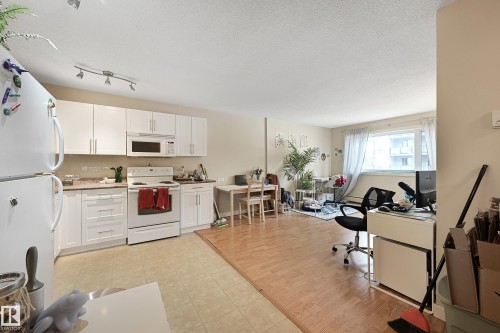 Kitchen featuring white cabinetry with brushed nickel hardware, white appliances, and a light-toned countertop - 901 9710 105 Street, Edmonton, AB - Indoor Photo Showing Kitchen