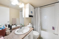 Bathroom featuring a white subway tile shower, white bathtub, vanity with a laminate countertop, white oval sink, and chrome faucet - 