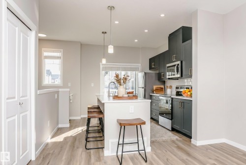 Kitchen featuring dark cabinetry, stainless steel appliances, white countertops, and a white subway tile backsplash - 320 Secord Boulevard, Edmonton, AB - Indoor Photo Showing Kitchen