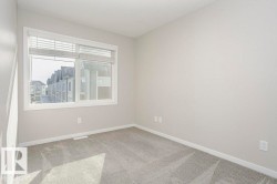 Bright room featuring a window with blinds, light-colored walls, and carpeting - 