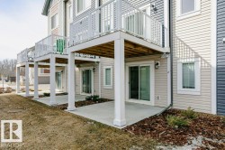 The property features exterior siding, sliding glass doors, and balconies with white railings - 