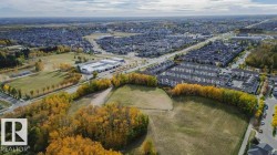 Expansive aerial view showcasing the surrounding residential area and abundant green spaces - 