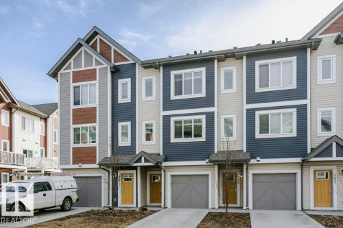 The property features a multi-story exterior with horizontal siding in varying colors, including blue, grey, and reddish-brown - 320 Secord Boulevard, Edmonton, AB - Outdoor With Facade