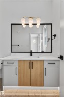Contemporary vanity featuring a light wood-finish center and light gray side cabinetry - 