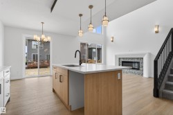 Modern kitchen island featuring wood-finish cabinetry, a white countertop, and a black gooseneck faucet - 