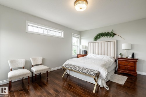 Spacious bedroom featuring rich wood-finish flooring, light grey walls, and white baseboards - 2036 Towne Centre Boulevard, Edmonton, AB - Indoor Photo Showing Bedroom