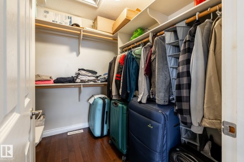 Walk-in closet featuring wood-finish flooring, white walls, and built-in shelving - 2036 Towne Centre Boulevard, Edmonton, AB - Indoor With Storage