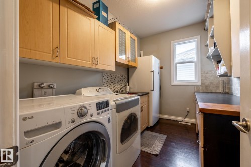 Dedicated laundry area featuring wood-finish flooring, light wood cabinetry, and a window - 2036 Towne Centre Boulevard, Edmonton, AB - Indoor Photo Showing Laundry Room