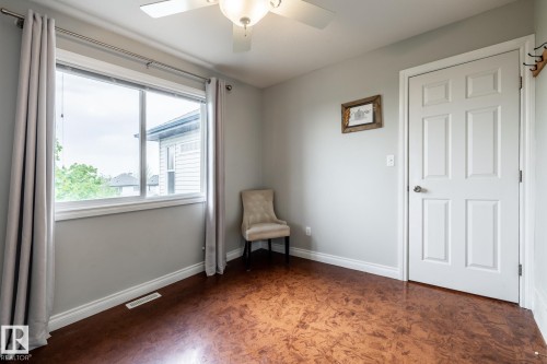 Bright room featuring wood-finish flooring, a contemporary ceiling fan with light fixture, and a white paneled door - 2036 Towne Centre Boulevard, Edmonton, AB - Indoor
