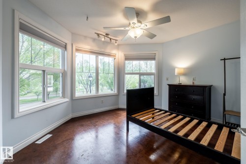 Room featuring multiple windows, a ceiling fan with integrated lighting, and dark wood-finish flooring - 2036 Towne Centre Boulevard, Edmonton, AB - Indoor Photo Showing Bedroom
