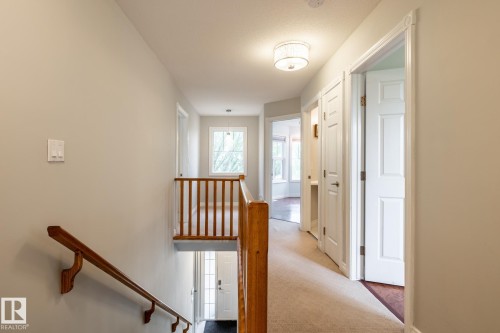 Upper-level hallway featuring a carpeted floor, white paneled doors, and a decorative ceiling light fixture - 2036 Towne Centre Boulevard, Edmonton, AB - Indoor Photo Showing Other Room