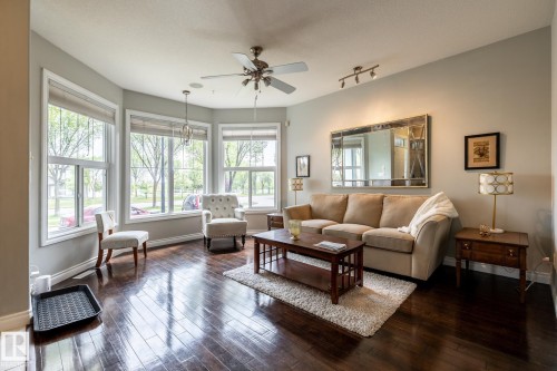 Bright living space featuring dark wood-finish flooring, a bay window with multiple panes, ceiling fan, recessed lighting, and track lighting - 2036 Towne Centre Boulevard, Edmonton, AB - Indoor Photo Showing Living Room